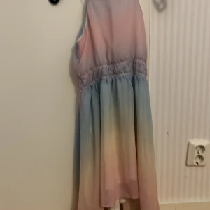 Pastellfärgad klänning från H&M - Säljer en söt ärmlös klänning från H&M i härliga pastellfärger som rosa, blå och gul. Klänningen har en elastisk midja för en bekväm passform. Perfekt för sommarens varma dagar! 🌸