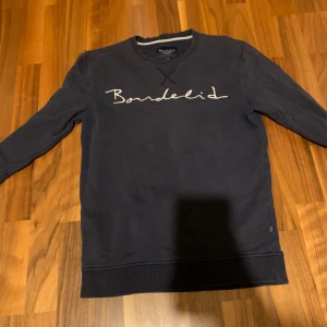 Mörkblå tröja från Bondelid - Säljer en stilren mörkblå tröja från Bondelid med deras logga broderad på framsidan. Tröjan har långa ärmar och ribbade muddar vid ärmslut och nederkant. Perfekt för en avslappnad stil. Nypris cirka 799 mitt pris 349 uppen för bud kol privat för fler bilder eller någon annan tanke.