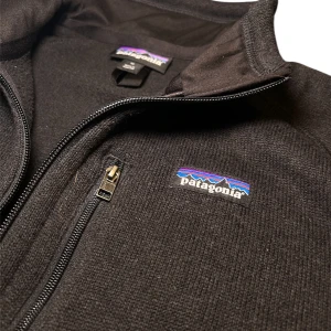 Patagonia Better Sweater  - Säljer en svart fleecetröja från Patagonia med dragkedja och en liten bröstficka. Jackan har en stilren design med långärmade ärmar och är perfekt för kyligare dagar. Den är tillverkad i mjukt fleece-material som håller dig varm och bekväm. Storlek M. Väldigt bra skick