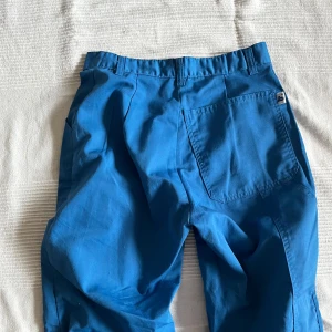 Blå byxor med vida ben - Snygga blå vintage byxor med vida ben och hög midja. Midjemåttet tvärsöver är 36 cm och innerbensmåttet är 82 cm🌟