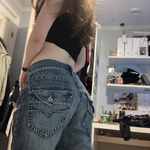 Guess rancho jeans med broderade fickor - Snygga jeans ifrån guess med broderade detaljer på bakfickorna. Perfekta för en avslappnad stil. Skriv gärna för fler foton eller frågor 💞💞 midjemått: 38cm innerbenslängd:  77cm Rise: 24cm