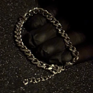 Silverfärgat cuban link armband - Snyggt silverfärgat armband med en klassisk kedjedesign. Perfekt för att ge en stilren touch till din outfit. Armbandet har en justerbar kedja för att passa olika storlekar.