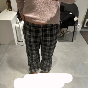 Svarta och vita rutiga mysbyxor! - Jag säljer ett par svarta och vita rutiga byxor med stretchig midja! Byxorna har en avslappnad passform och är perfekta för en en dag efter skolan. De är tillverkade i ett mjukt material, men dock lite noppriga! Jag vet tyvärr inte vart de kommer ifrån eftersom att klappen är bortklippt.💕💕