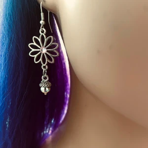 By prisförslag- 1 st Blomformade silverörhängen med kotte - Charmigt örhängen i silver med blomdesign och en glittrande pärla i mitten. Hängande stil med en liten natur detaljer längst ner som ger en elegant touch. Perfekta för att lägga till lite bling till din outfit!