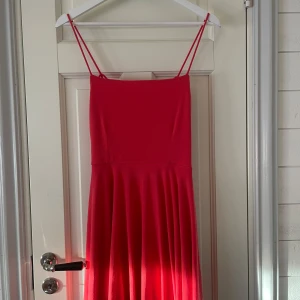 Rosa klänning från  - Skrikrosa klänning från BikBok. Använd en gång utomlands. Jättefin på sommaren och jätteskönt material🩷                                              Liten fläck på sidan men det syns inte eftersom den sitter där man inte kollar🙃Om man vill se hur den ser ut på är det bara och fråga😊