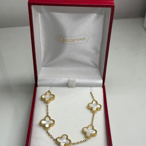 Guldarmband med vita klövermotiv - Säljer detta eleganta armbandet jag har men andvänder tyvärr inte guld, jag tror inte det är från guldfynd utan det bara är förvaringsbox. Den är Guldplaterad så den rostas inte. Jätte fint skick. Pris kan defenetivt diskuteras då ja inte vet vart den är från. 