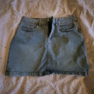 Jeanskjol från The People Rep - Snygg jeanskjol från The People Rep i klassisk blå denim. Kjolen har en kort längd med femficksdesign och dragkedja fram. Köpt i Italien. Skriv prisförslag Elle Rom ni har frågor