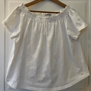 Vit offshoulder blus från Hampton Republic - Säljer en söt vit offshoulder blus från Hampton Republic. Blusen har korta ärmar och en elastisk kant runt axlarna för en bekväm passform. Perfekt för en avslappnad sommarlook.Storlek M