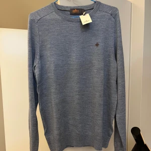 Helt ny ljusblå merinoulltröja från Morris - Säljer en stilren ljusblå tröja från Morris i 100% merinoull. Tröjan har en liten broderad logga på bröstet och rund halsringning. Perfekt för kyligare dagar med sin mjuka och bekväma passform. Helt ny med lapp på! TTS storlek S :)