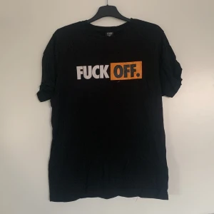 Svart t-shirt med tryck från FSBN - Säljer en svart t-shirt från FSBN med ett iögonfallande tryck i vitt och orange på framsidan. T-shirten har en normal passform och är kortärmad, perfekt för en avslappnad stil.