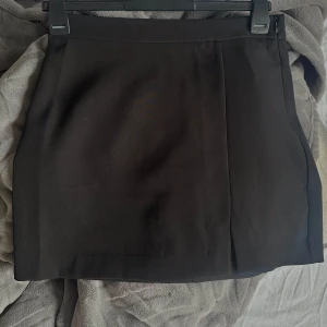 Svart kjol från ONLY - Snygg svart kjol från ONLY i en klassisk design. Kjolen har en kort längd och en stilren look som passar perfekt till olika tillfällen. Den är tillverkad i ett mjukt och bekvämt material som ger en skön passform.