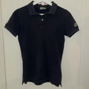 Moncler Pike - Moncler Magnus Polo Manica Corta, saknas en knapp i kragen. Storlek 12år 152cm, perfekt till en lillebrorsa. Har även en cool design när man viker upp kragen då det står Moncler med vid färg. Vid frågor är det bara att skriva!