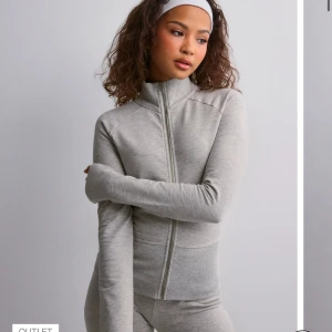 Grå zip-up hoodie - Snygg och bekväm grå zip-up hoodie med lång ärm och dragkedja framtill, från Nelly!  Perfekt för en avslappnad stil eller träning. Använt 1 gång, köpt in för ca 200kr 