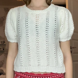 Vit stickad tröja från H&M - Säljer en söt vit stickad tröja från H&M med korta puffärmar och ett fint hålmönster. Perfekt för en stilren look. Tröjan har en rund halsringning och ribbade kanter. Kostade 200 kr när jag köpte den. Den är jätte fin och super skön 😍använd runt 5 gånger 
