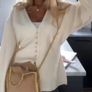 Vit kofta med knappar - Säljer denna trendiga tröja ifrån Gina Tricot. Köpt för ett par veckor sedan och är helt som ny. Inga defekter, nypris 399kr❤️