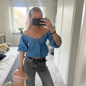 Blå offshoulder blus - Säljer en söt blå offshoulder blus med puffiga trekvartsärmar. Perfekt för en avslappnad sommarlook. Blusen har en luftig passform och är lätt att matcha med jeans eller kjol.