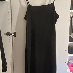 Svart klänning från 157 - Snygg svart långklänning från 157 med smala axelband och enkel design. Använd endast fåtal gånger. Storlek s men passar xs också beroende på hur man vill att den ska sitta, materialet är relativt strechigt💕