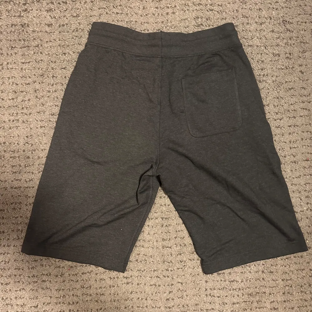 Snygga mörkgrå shorts från Everlast med snörning i midjan. Perfekta för en avslappnad stil. De har en bakficka och är tillverkade i ett mjukt material för extra komfort.. Shortsit.
