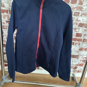 Mörkblå fleecejacka från Rocktrail - Säljer en mörkblå fleecejacka från Rocktrail med en kontrasterande rosa dragkedja. Jackan har långa ärmar och en enkel design som passar perfekt för kyliga dagar. Perfekt för dig som gillar att hålla det stilrent och bekvämt. 🧥