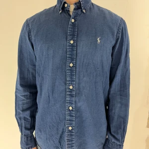 Blå skjorta från Ralph Lauren - Fin Ralph Lauren oxford skjorta i indigo färg. Den är i storleken medium. Modellen är 173cm och väger 65kg.