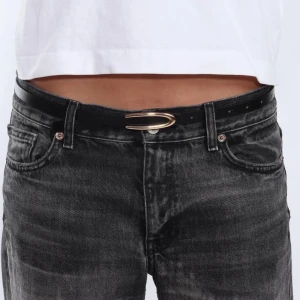 Svart bälte med gulddetalj - Snyggt svart bälte med en elegant guldfärgad spänne. Perfekt för att ge en stilren touch till din outfit. Passar bra till jeans eller andra byxor. Ett måste i garderoben för den modeintresserade.