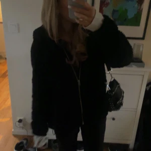 Svart teddyjacka med dragkedja - Mysig svart teddyjacka med dragkedja framtill. Perfekt för kyliga dagar. En stilren och bekväm jacka för alla tillfällen. Köpt på hm!