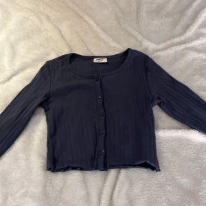 Mörkblå kofta från Kappahl - Säljer en mörkblå kofta från Kappahl med knappar framtill. Storlek 146/152. Nästan oanvänd. 