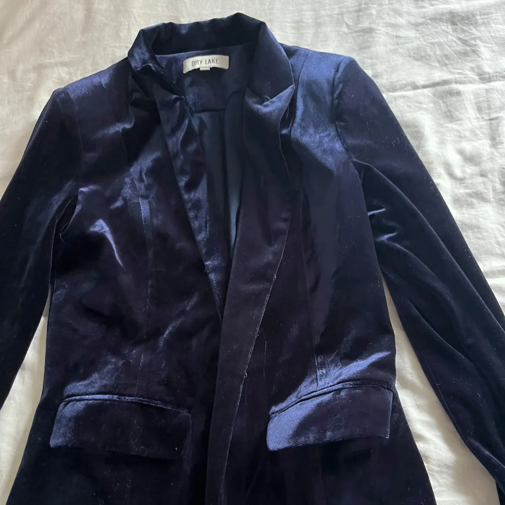 Blazer i mörkblått sammetstyg, sjukt snygg! Har små puffar i axlarna, fina detalj fickor och super skön!. Puvut & Bleiserit.