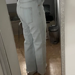 Ljusblå jeans med bootcut - Snygga ljusblå jeans med bootcut-stil och hög midja. Perfekta för en avslappnad look. De har klassiska fem fickor och en knappgylf.