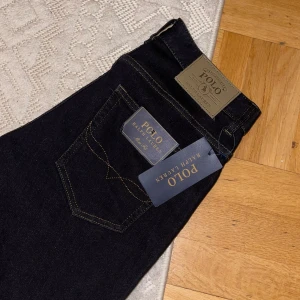 Svarta jeans från Ralph Lauren - Sprillans ny (alldales för lång för mig) snygga svarta jeans från Ralph Lauren med klassisk design. De har en knapp med logotyp och kontrasterande sömmar. Perfekta för en stilren look. (Slim fit) Orginal pris: 1700kr