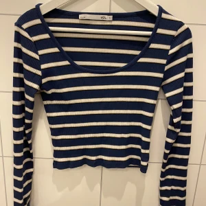 Randig ribbad topp från Lager 157 - Säljer en snygg randig topp från 157 i blått och vitt. Toppen är ribbad med långa ärmar och en rund halsringning. Perfekt för en stilren look!