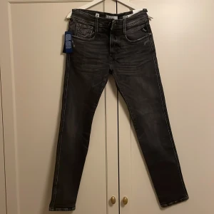 Grå jeans från Replay - Snygga grå jeans från Replay med en modern slim passform. De har en klassisk femficksdesign och en diskret tvättad look. Perfekta för en stilren vardagsoutfit.