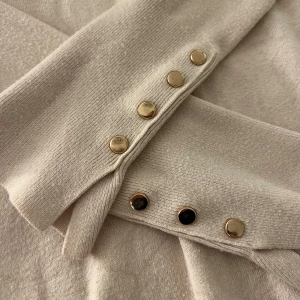 Beige tröja från Zara med guldknappar - Säljer en stilren beige tröja från Zara i storlek S. Tröjan har långa ärmar med eleganta guldknappar. Finns små defekter vit kragen, men går att sy ihop enkelt💓💓
