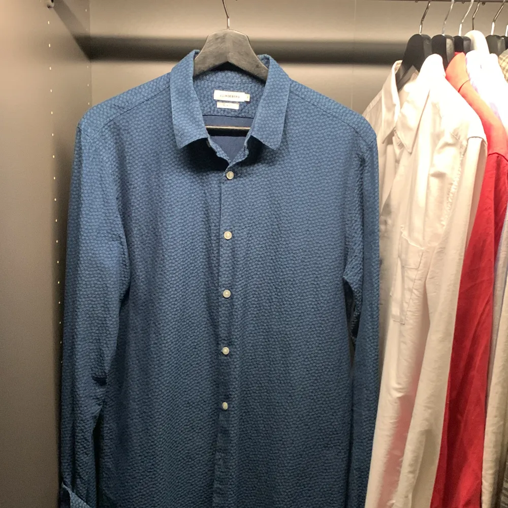 Snygg blå skjorta från J.Lindeberg i slim fit. Skjortan har ett diskret mönster och knappar framtill. Perfekt för en stilren look. Använd få tillfällen och nypris ligger runt 1500 men jag säljer den för 600 . Paidat.
