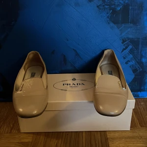 Beige loafers från Prada - Snygga beige loafers från Prada i skinn. Dessa eleganta skor har en klassisk design med rundad tå och subtila detaljer. Perfekta för en stilren look kommer med box priset kan diskuteras,mvh Frida