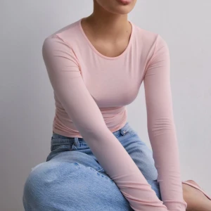 Ljusrosa långärmad topp - Långärmad topp från Nelly med tight passform. 🫶🏻