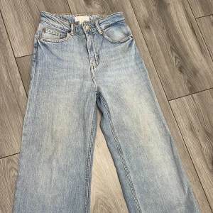 Blå jeans från H&M - Snygga blå jeans från H&M i st 34. De har en hög midja och en rak passform som ger en avslappnad look. Perfekta för en stilren vardagsoutfit. Längd - passar perfekt om man är runt 160 cm