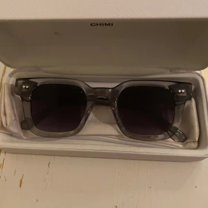Grå Chimis - Chimi i fint skick. Säljs då jag köpt nya. Glasögonen är i fint skick men duken och påsen har synliga defekter. Chimis använda flertal gånger men inga synliga repor osv. Kontakta för fler bilder 😃Kan gå ner i pris 