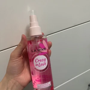 La Rive Crazy in Love Body & Hair Mist - Säljer en fräsch och blommig body & hair mist från La Rive. Flaskan är genomskinlig med rosa vätska. Perfekt för att fräscha upp sig under dagen med en doft av kärlek och energi. Innehåller vitamin E och provitamin B5 för extra vård. Ca 85% återstår. 