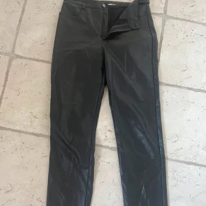 Svarta skinnbyxor  - Svarta skinnbyxor från Nelly i fauxskinn. Snygga i modellen och högmidjade 