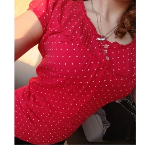 Röd prickig blus - Säljer en söt röd blus med vita prickar. Den har korta ärmar och knappar framtill. . Blusen är i bra skick och passar till både jeans och kjol. 🌸