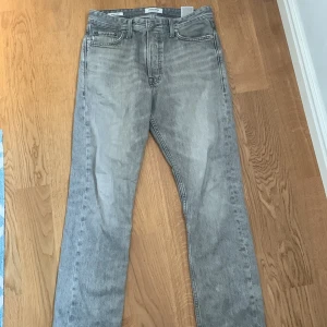 Grå jeans från Jack & Jones -  Tjena! Säljer ett par grå jeans från Jack & Jones i loose fit man får även med ett Peak Performance bälte om man köper jeansen. Dem är i bra skick och har inte används på länge. Tveka inte att skicka om pris eller något annat du undrar!