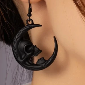  Helt nya Svarta månskalle-örhängen - Coola svarta örhängen i form av en halvmåne med en skalle. Perfekta för att ge en edgy touch till din outfit. De är lätta och bekväma att bära hela dagen. Passar perfekt till Halloween eller en rockig festkväll. 🖤