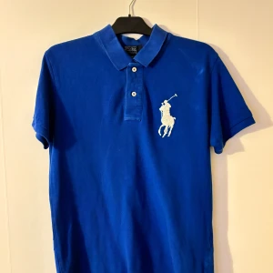 Ralph Lauren piké - Blå Ralph Lauren piké, fått av nära släkt, använd ett par gånger, inga synliga skador, skick 8/10.