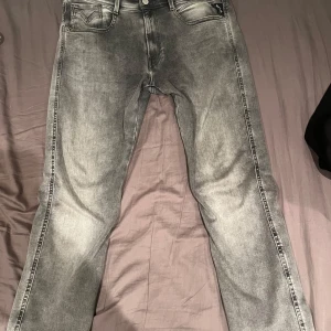 Grå Replay Anbass Jeans - Säljer ett par snygga grå Replay Anbass jeans i storlek 31. De har en klassisk femficksdesign och en bekväm passform. Perfekta för både vardag och fest! 🖤