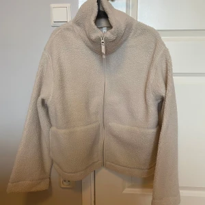 Ny teddyjacka / pilejacka H&M - Ny med tags. Naturvit / ljusbeige. Storlek M. Den är ganska liten i storlek så gå gärna upp en eller storlekar för att ha utrymme för tjocktröja under. 