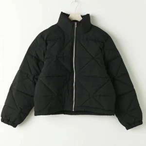 Svart pufferjacka - Säljer en snygg svart pufferjacka i nyskick. Den har en dragkedja framtill och är quiltad för extra värme. Perfekt för höst och vinter! Jackan har långa ärmar och en normal passform. Superbekväm och stilren för alla tillfällen. Aldrig använd