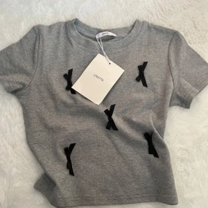 Koreansk T-shirt  - Helt ny koreansk T-shirt med rosetter på. Är i one size men passar xs/s. Aldrig använd, med lappar kvar.