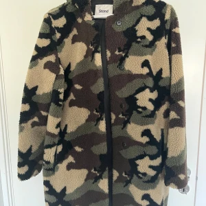 STAND STUDIO kappa med huva - ESTELLE COAT Teddy Varm Använt men gott skick. Inget att anmärka på.  Normal i storleken. Två ytterfickor. En innerficka med dragkedja.