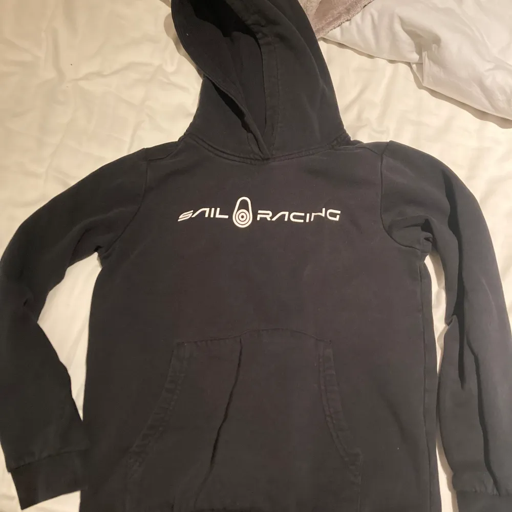 Svart sail racing tröja med luva i storlek 140. Använd och är för liten nu på sonen . Hoodies.